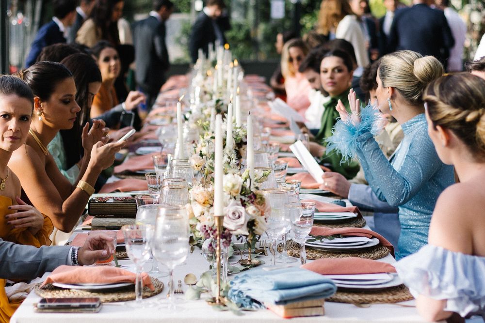 Long wedding reception table with elegant place settings and floral centerpieces.