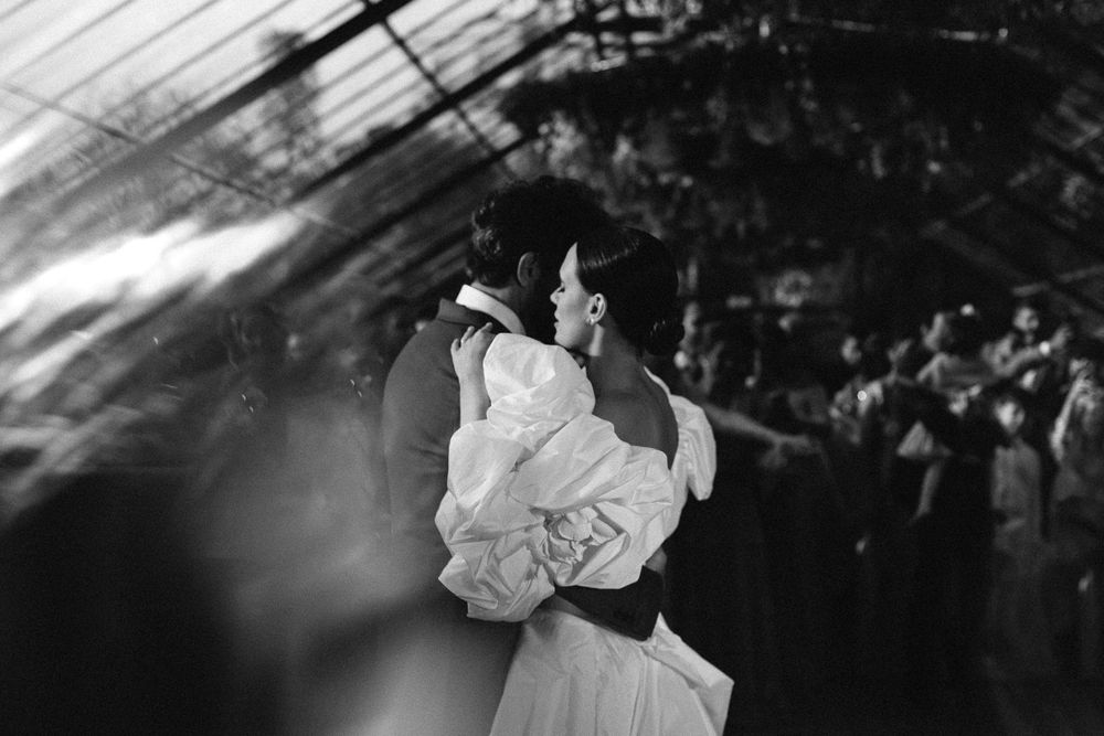 Black and white photo capturing dancing couple in dramatic lighting.