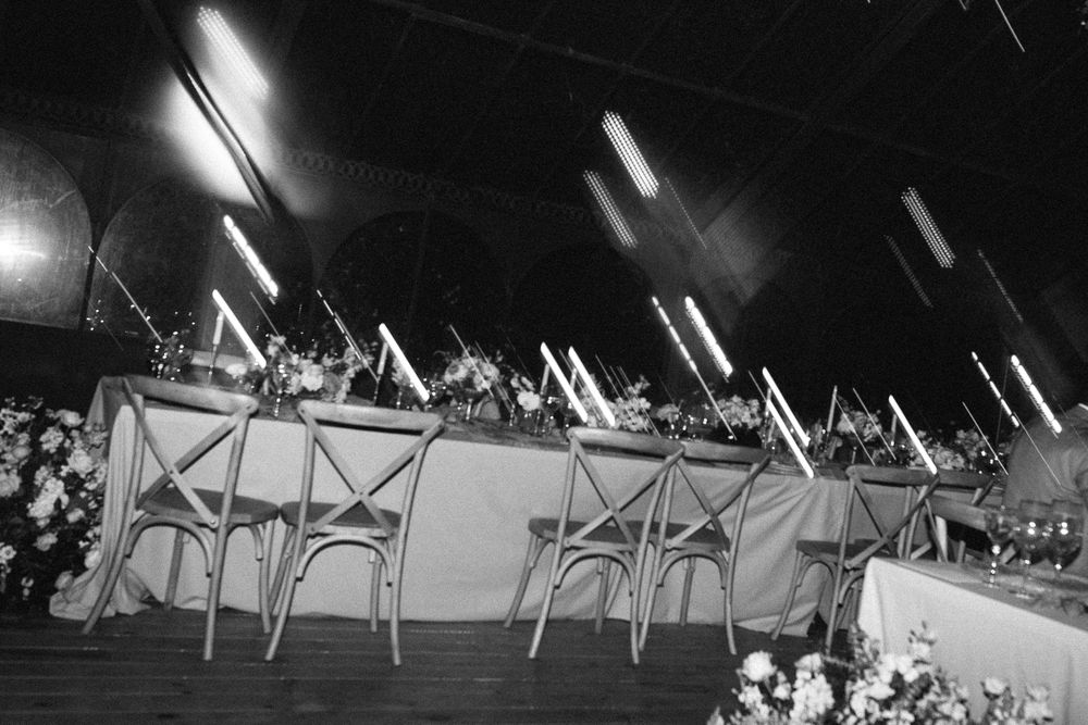 Empty bistro chairs lined up at an evening reception venue.