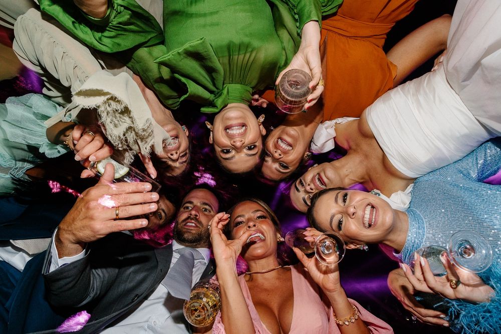 Wedding guests form a circle for a fun group photo from above.