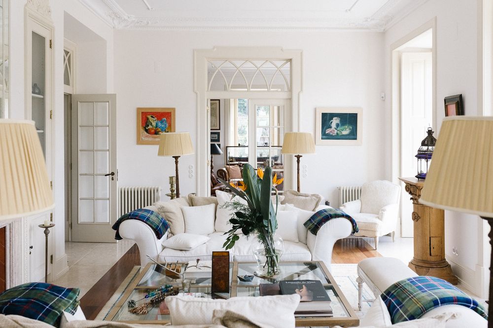 Bright, airy living room with white walls, matching sofas and elegant table lamps.