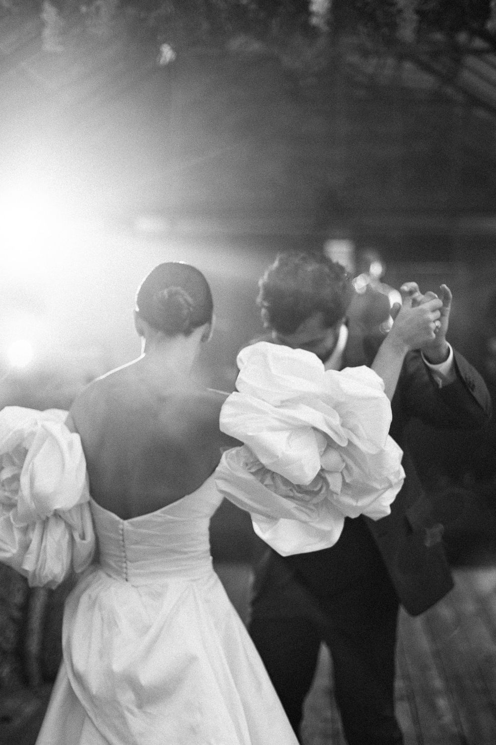 Black and white photo of couple dancing at their wedding reception.