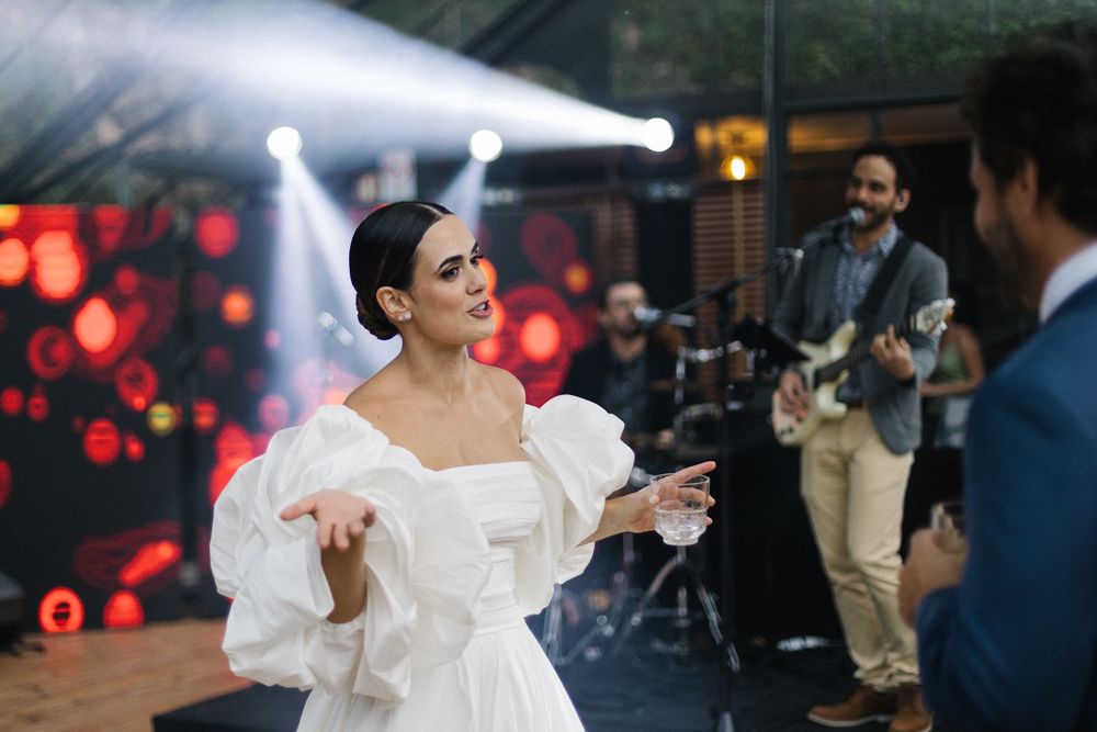 Wedding celebration with live music performance in a greenhouse setting.