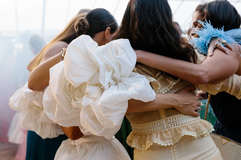 Group of wedding guests dancing and embracing in celebration.