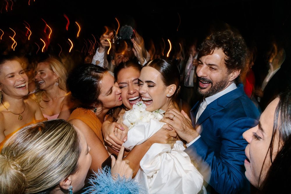 Joyful celebration on a crowded dance floor at a wedding reception.