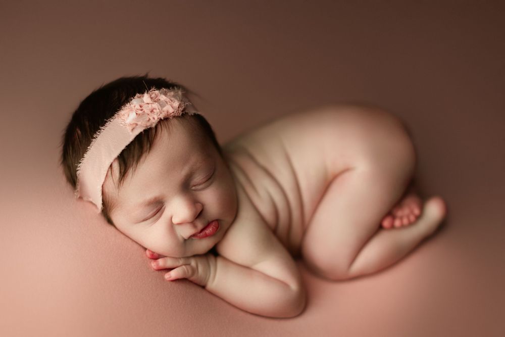 newborn girl on pink backdrop