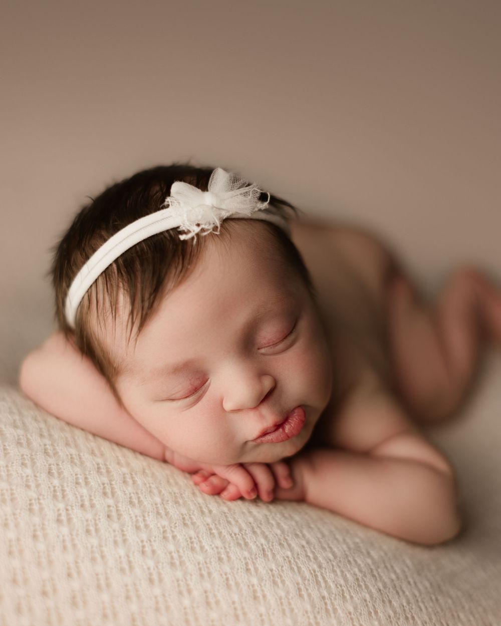 newborn girl on white backdrop for newborn session