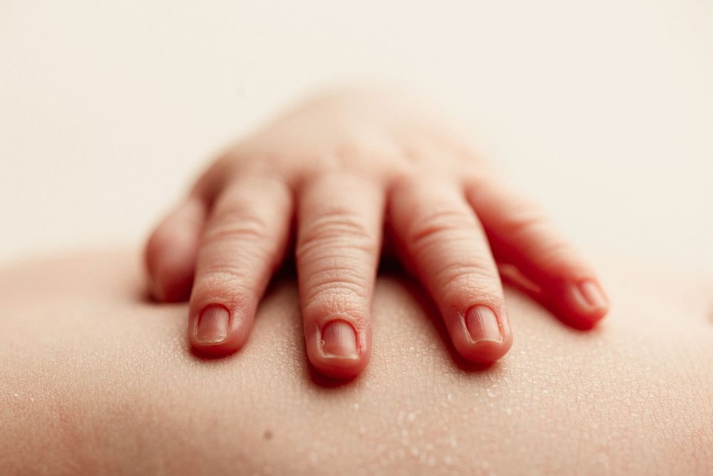 macro images of newborn hand on tummy