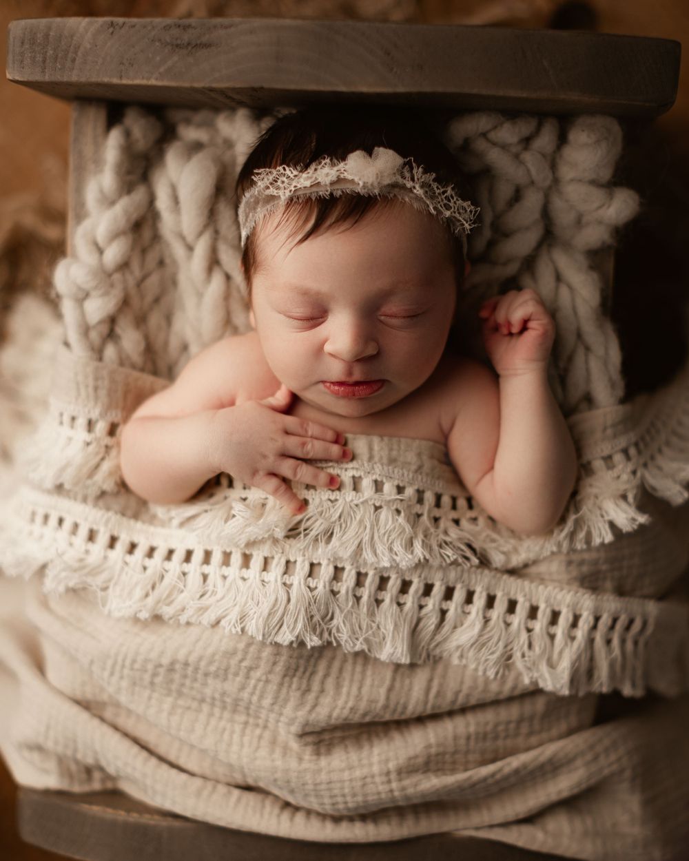 baby girl posed in a wooden prop crib sleeping