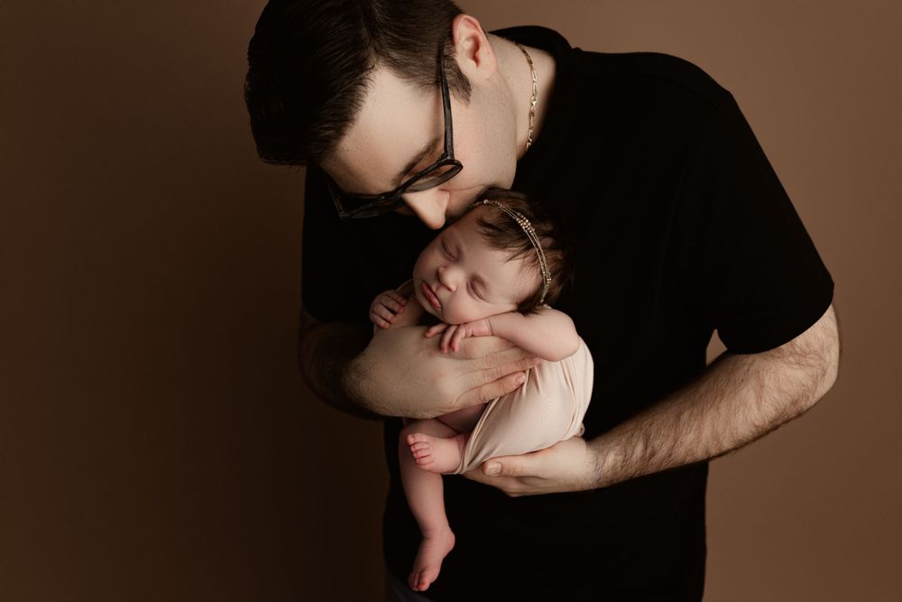 newborn photography calgary - dad holding and kissing his baby girl