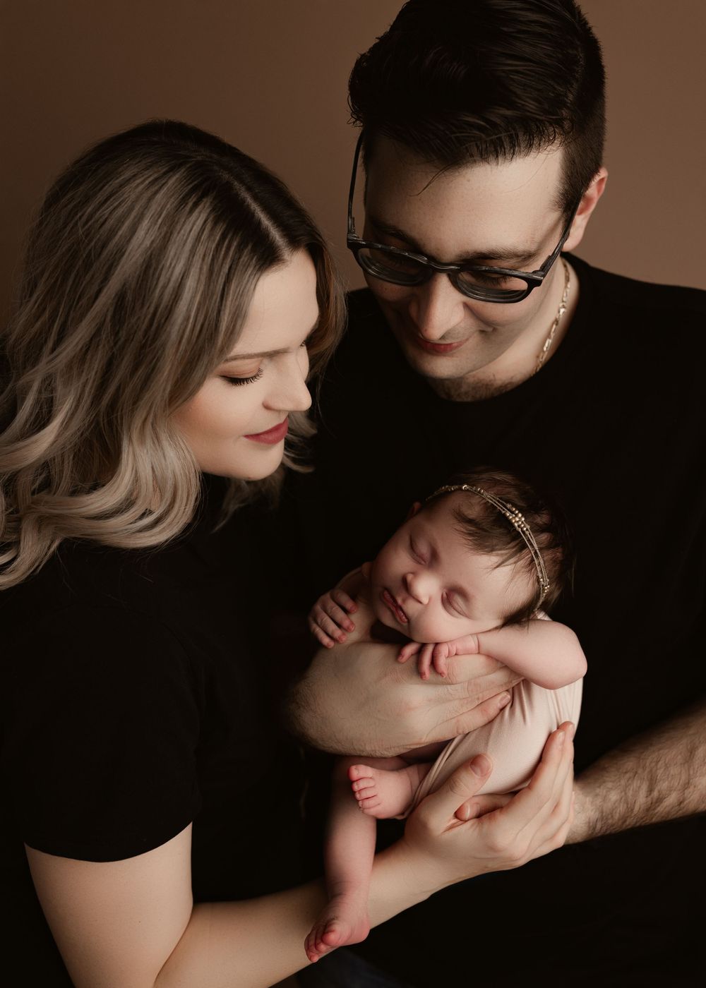 mom, dad, newborn baby girl posed for a family photo
