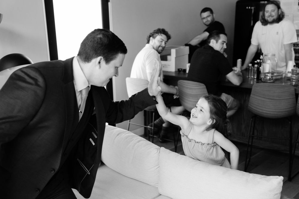 Groom high fives flower girl before wedding at Jorgensen Farms in Westerville, Ohio.