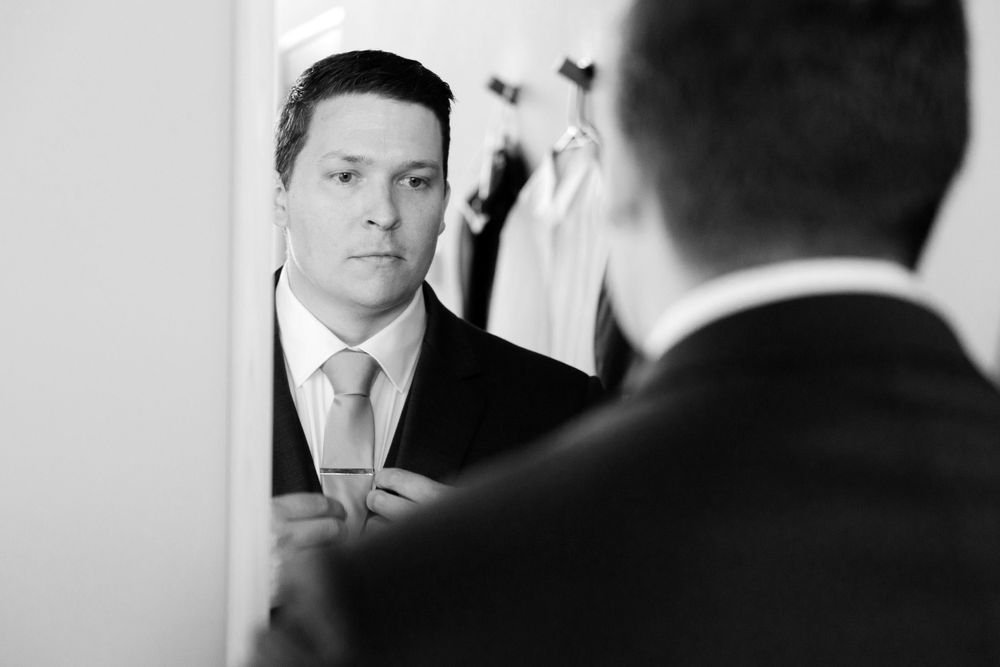Groom checks tie before wedding at Jorgensen Farms in Westerville, Ohio.