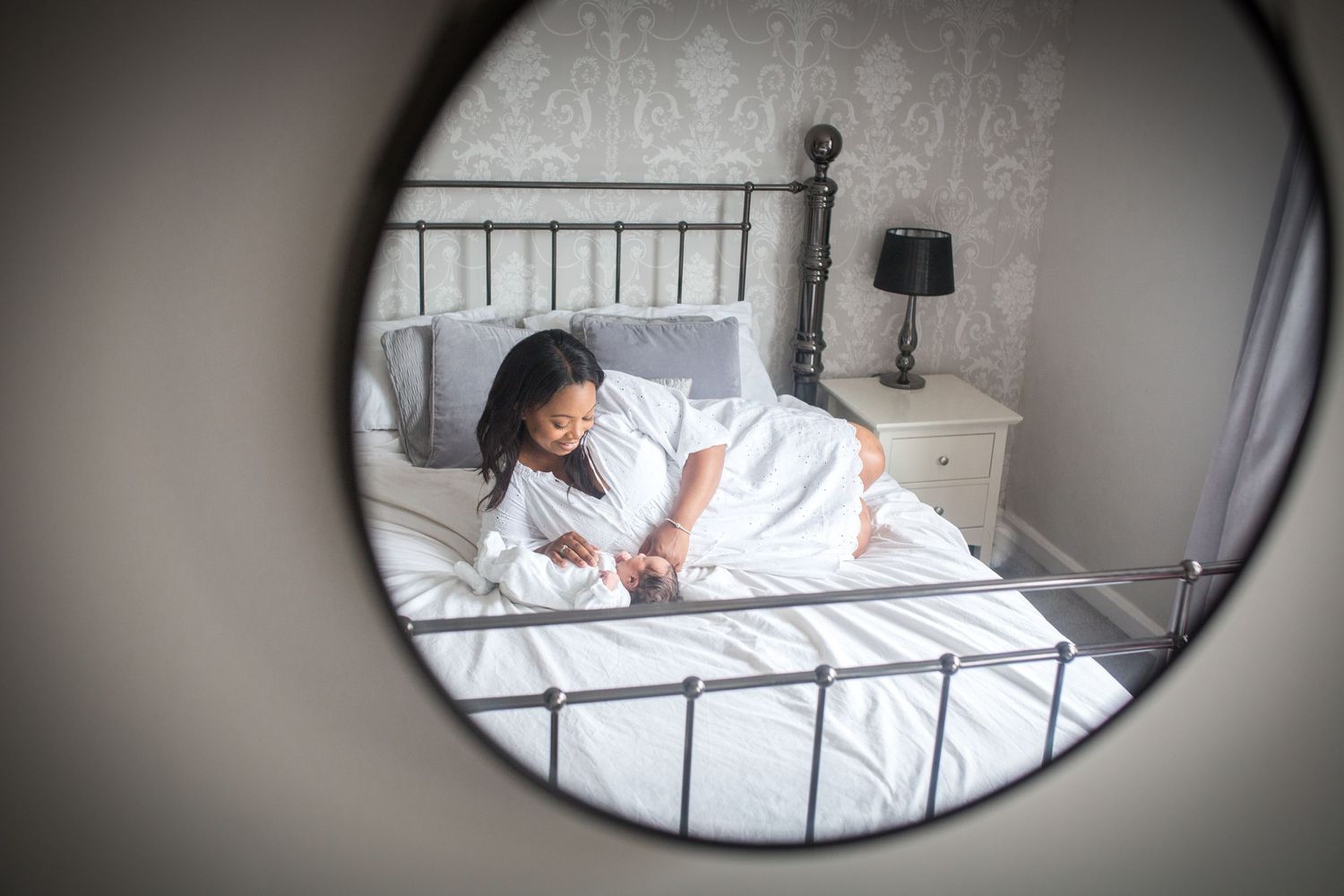 mother lying on a bed with newborn baby