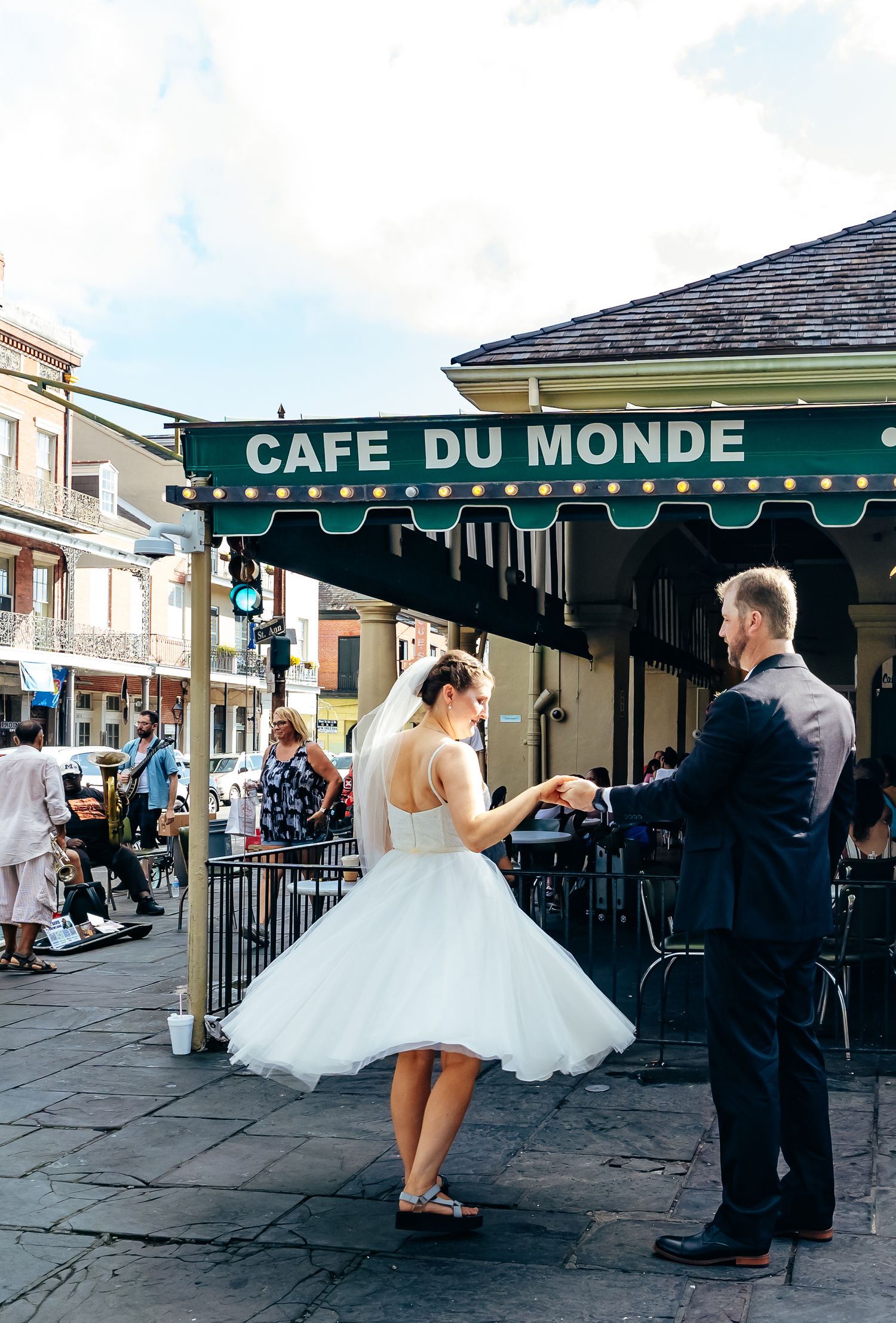 A wedding couple dancing together outside the historic Cafe Du Monde.