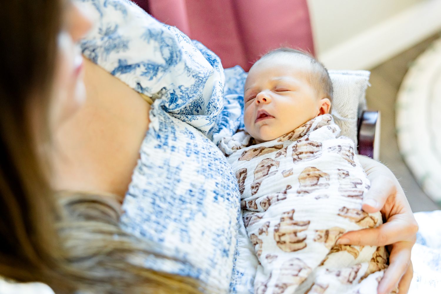 Close up of baby girl wrapped in blanket in her mom's arms during newborn photos in Colorado Springs.