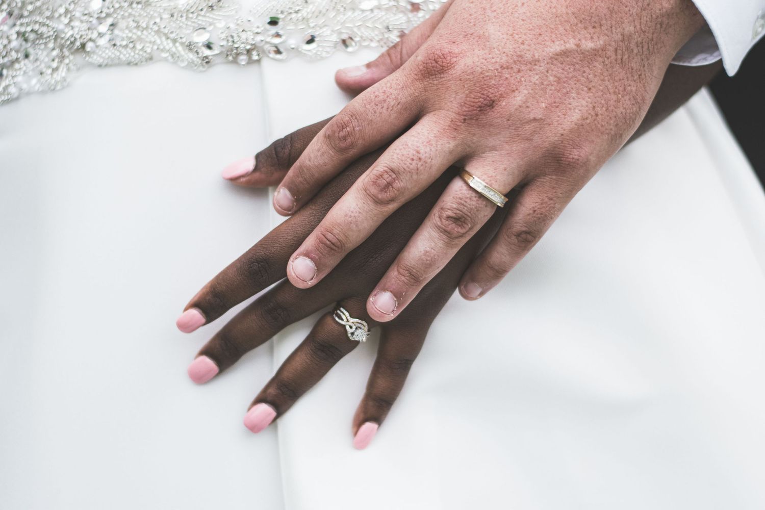 Close-up shots of hands with engagement ring on white surface.