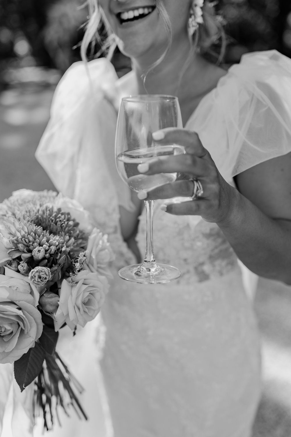 Wedding celebration with elegant floral bouquets and champagne glasses in a joyful outdoor setting.