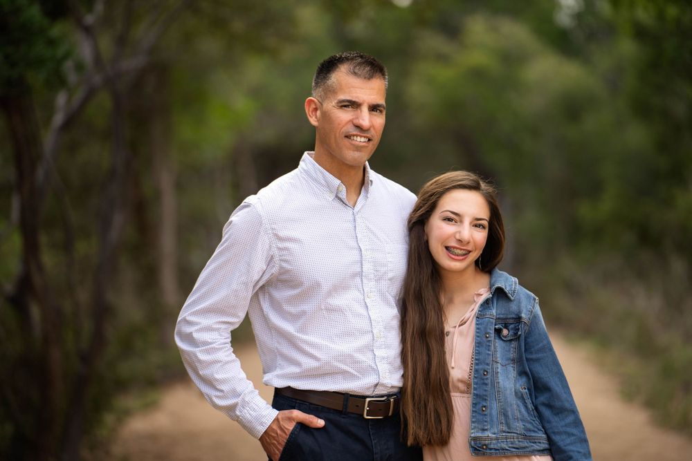dad wearing button down shirt with teen daughter in jean jacket