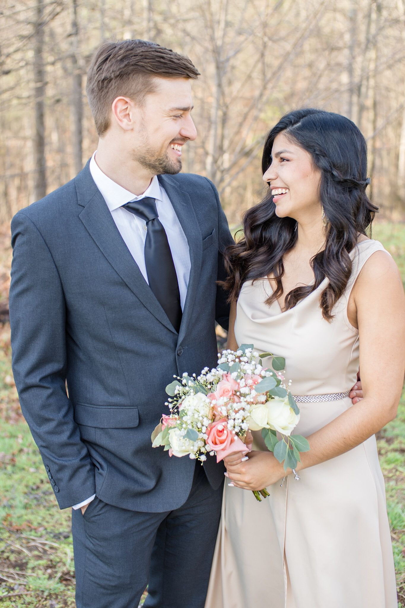 Bride and groom smiling at each other with so much love in their wedding day
