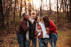 Large family in coordinating red and blue outfits for a woodland autumn photo session in Branson with L. Ballenger Photography.