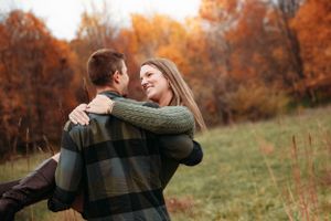 Marriedcouple embracing in a colorful autumn field in the Ozark Mountains with L. Ballenger Photography.