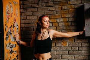 Urban-style senior portrait of a girl in a black top in Downtown Branson, captured by L. Ballenger Photography.