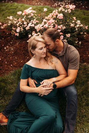 Outdoor maternity photo session in Branson featuring a woman in a green velvet gown by L. Ballenger Photography.