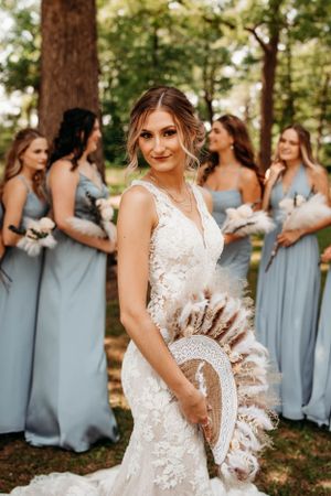 Elegant bride with bridesmaids at an outdoor venue, captured by Branson, MO Photographer L. Ballenger Photography.