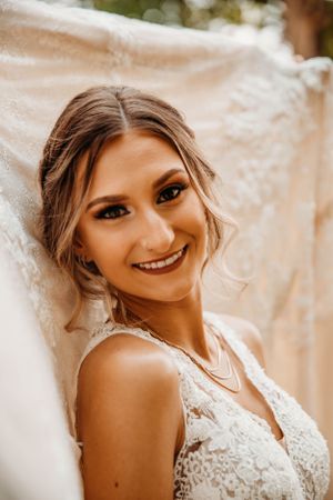 Stunning bridal portrait of a woman in a lace gown at a wedding venue by Branson, MO Photographer L. Ballenger Photography.