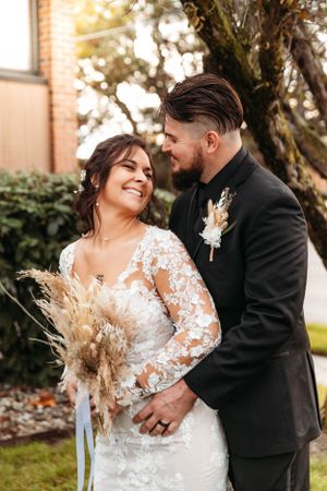 Bride and groom in traditional wedding attire posing at a venue, captured by Branson, MO Photographer L. Ballenger Photography.