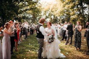 Outdoor wedding ceremony aisle with a bride and groom walking through guests by Branson, MO Photographer L. Ballenger Photography.