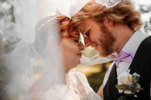 ntimate wedding portrait of a bride and groom under a veil in the Ozarks, captured by Branson, MO Photographer L. Ballenger Photography.