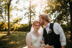 Intimate wedding portrait of a bride and groom in a sun-drenched field by Branson, MO Photographer L. Ballenger Photography.