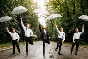 Groomsmen with umbrellas in a playful outdoor wedding party photo by Branson, MO Photographer L. Ballenger Photography.