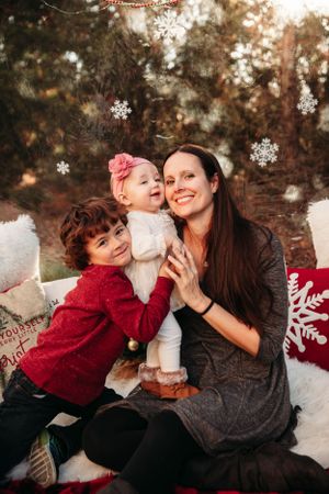 Festive indoor holiday photo session in Branson featuring a mother and two young children by L. Ballenger Photography.