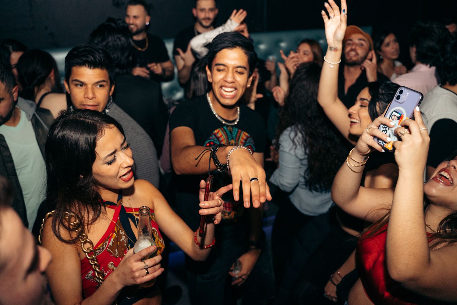 Energetic crowd dancing and celebrating at a lively nightclub party event.