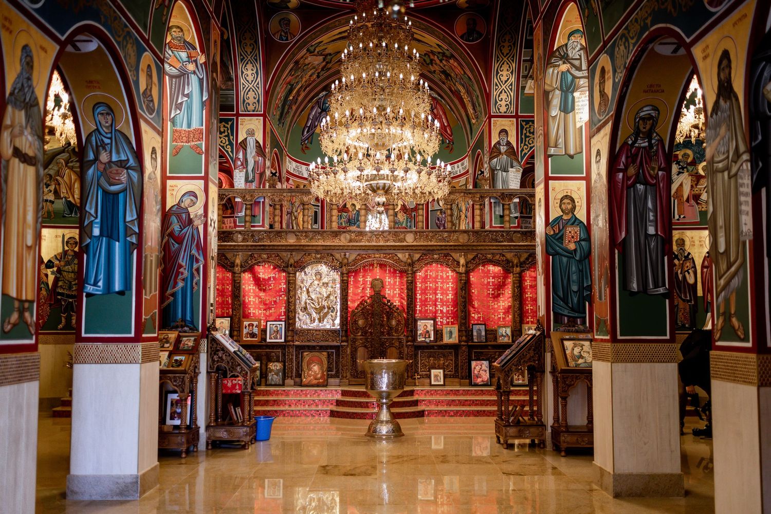 Ornate church interior with chandelier and decorative religious murals.