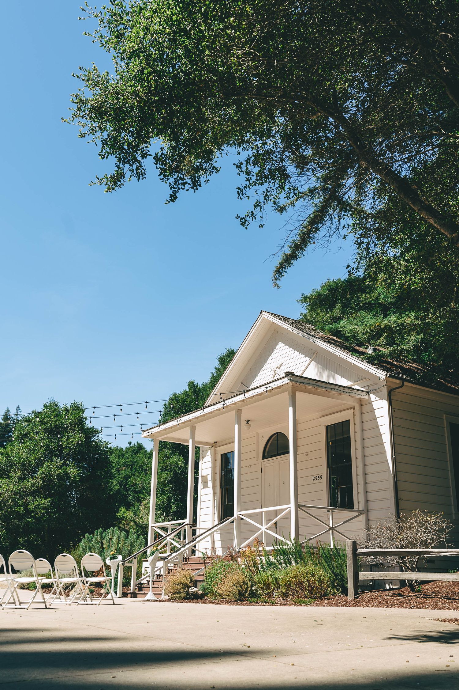 Valencia Hall is a small white building surrounded by trees.