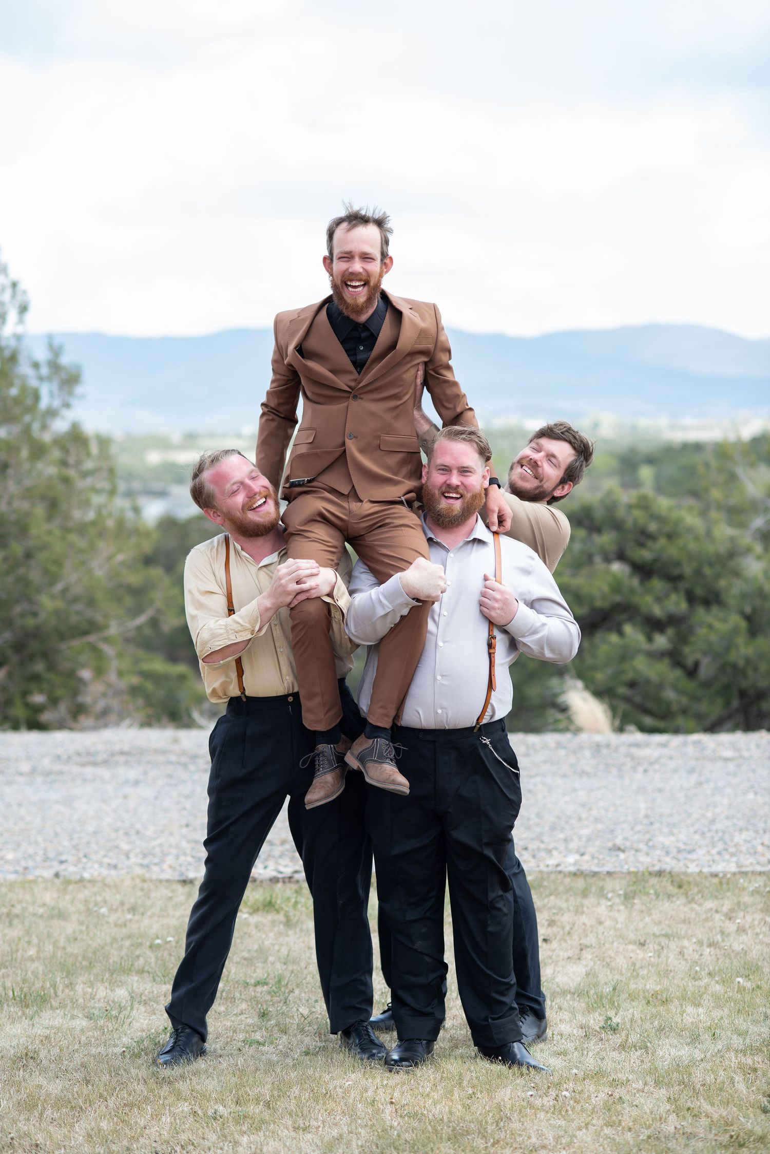 Groomsmen lifting Groom on their shoulders