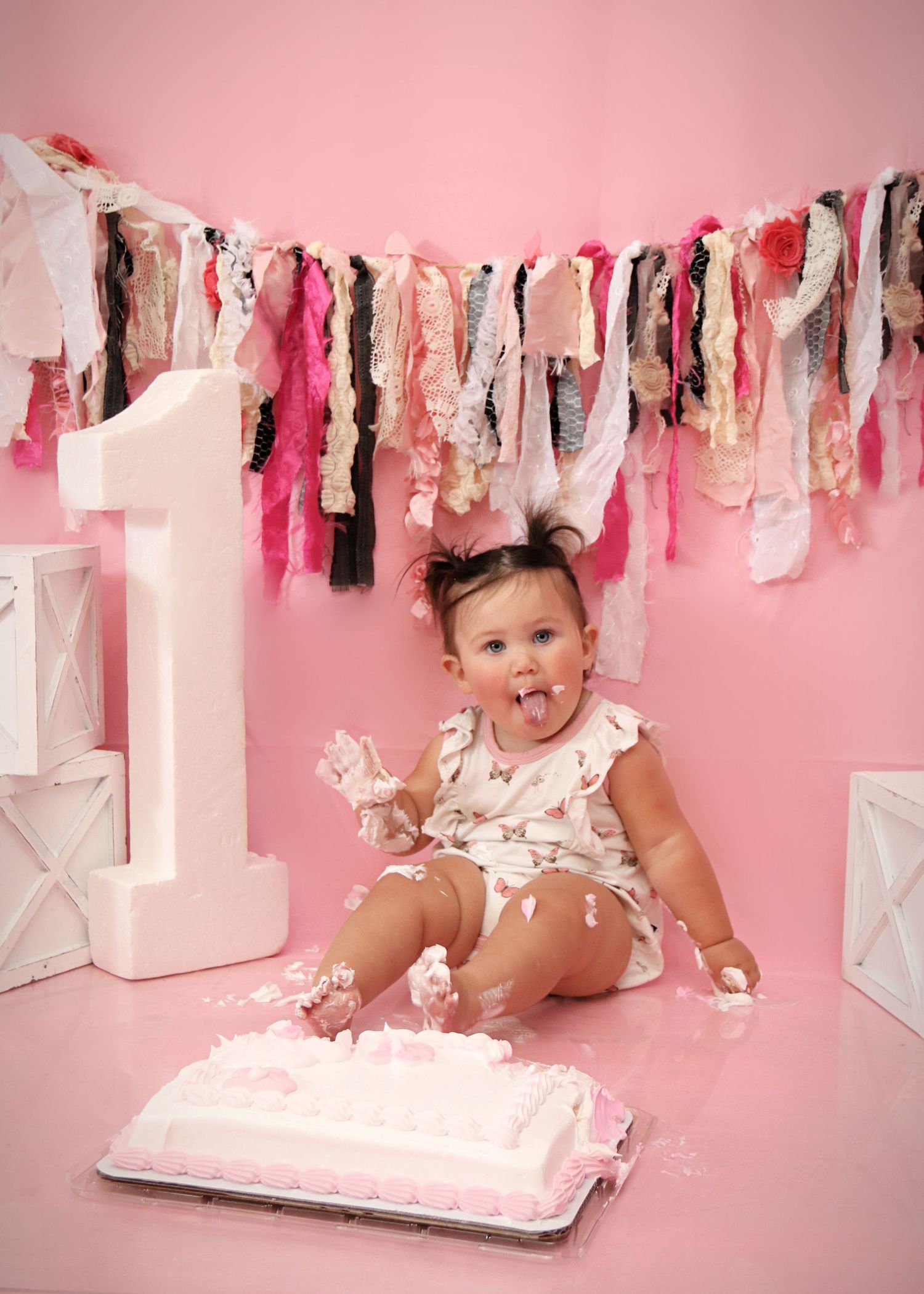 First birthday celebration setup with pink decorations and cake smash scene.