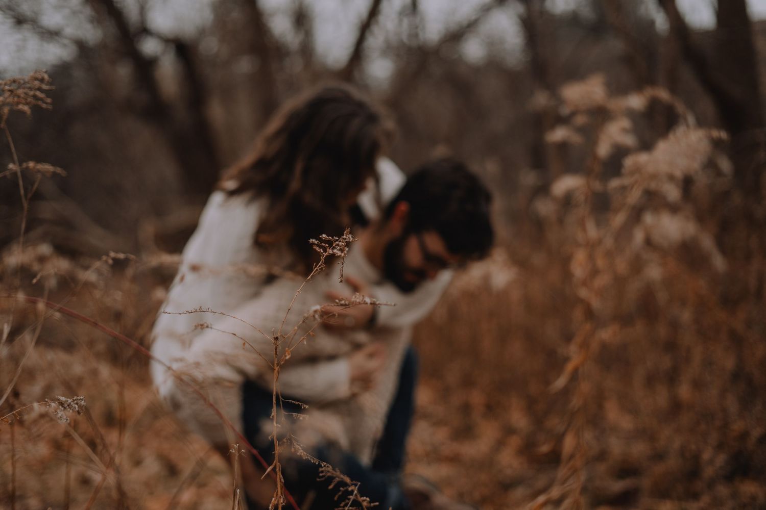 an out of focus image of an engaged couple enjoying a piggyback