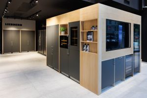 Modern kitchen showroom with Liebherr appliances and sleek built-in cabinetry.
