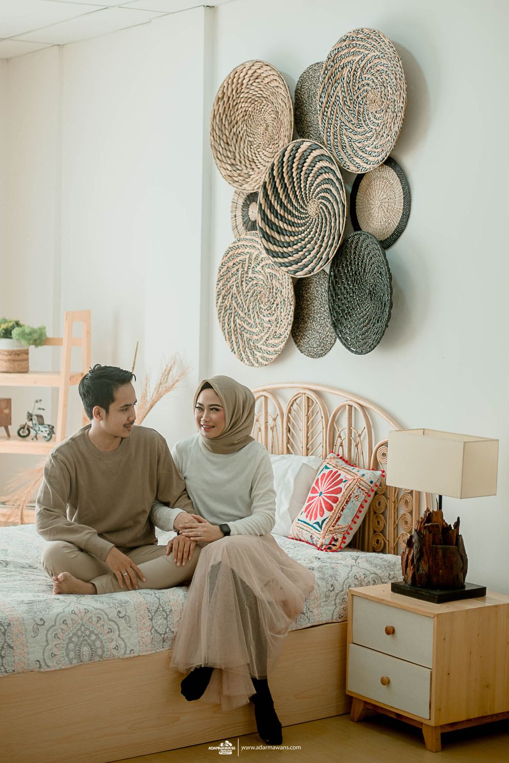 Cozy bedroom scene with rattan wall decor and neutral color scheme.