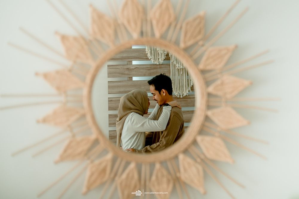 Reflection in decorative sunburst mirror showing intimate moment.