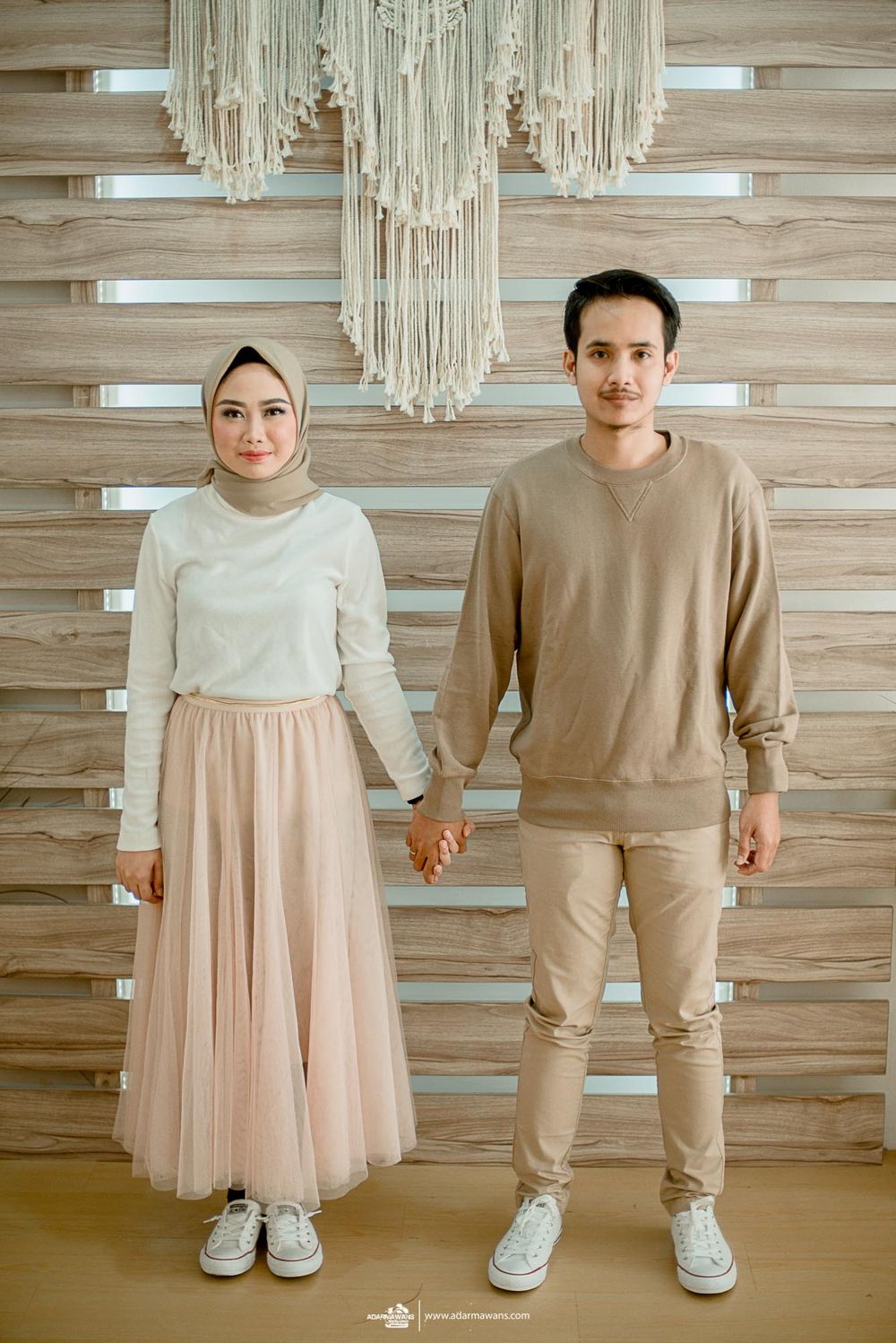Modern interior photoshoot with macrame wall hanging and wooden panel backdrop.