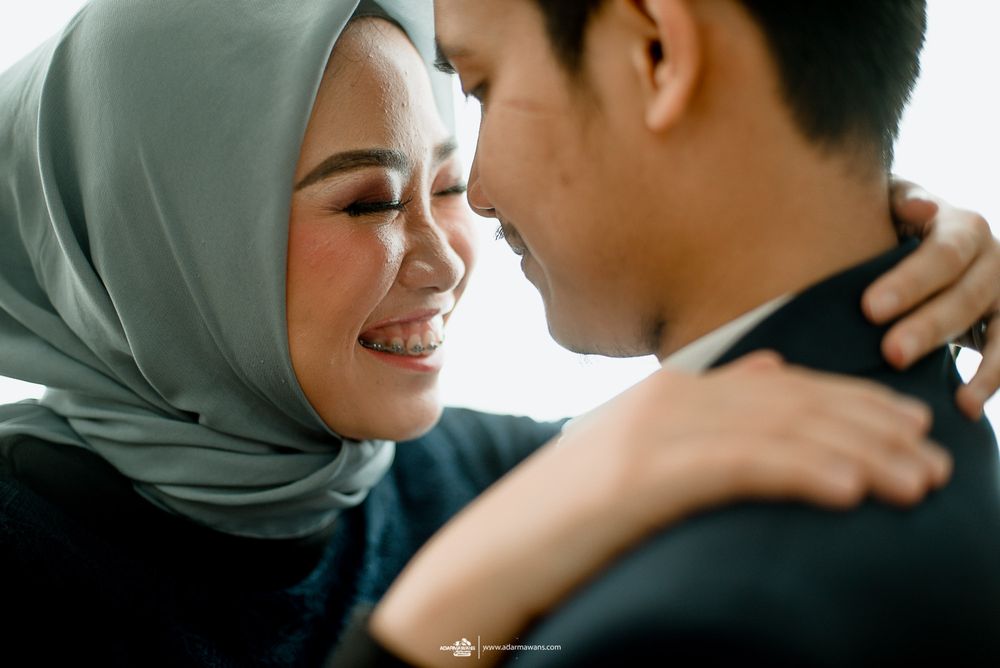 An intimate moment captured between a couple sharing a warm embrace and joyful smiles.