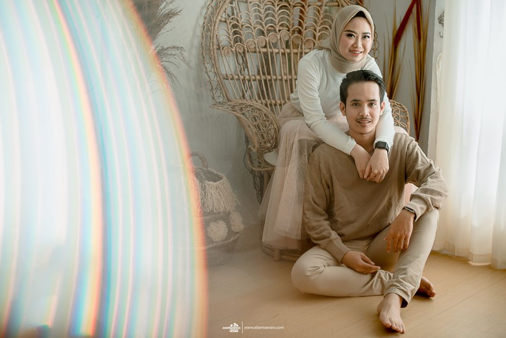 Casual couple relaxes together in bright, bohemian-styled room with natural decor.