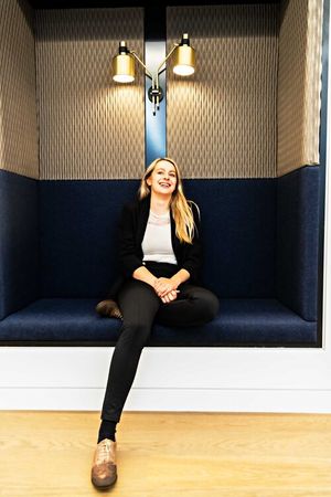 Professional relaxing in modern booth seating area with pendant lighting.