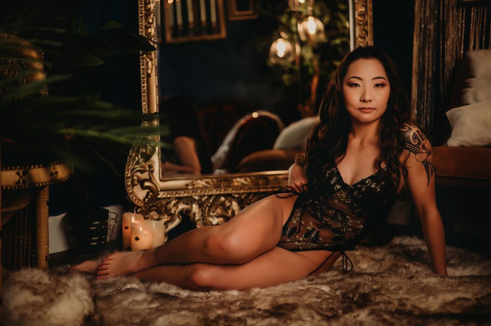 Elegant boudoir session with vintage furniture and warm ambient lighting.